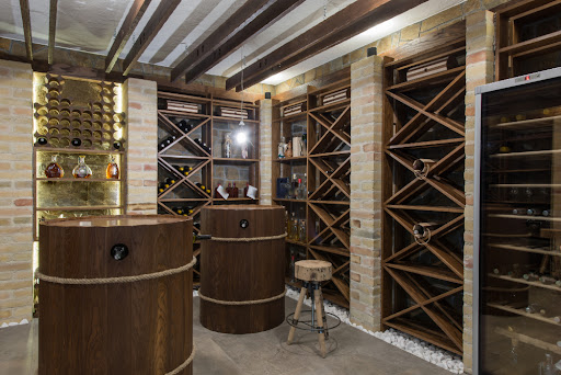 Cave à vins avec plusieurs casiers à vin et des bouteilles.